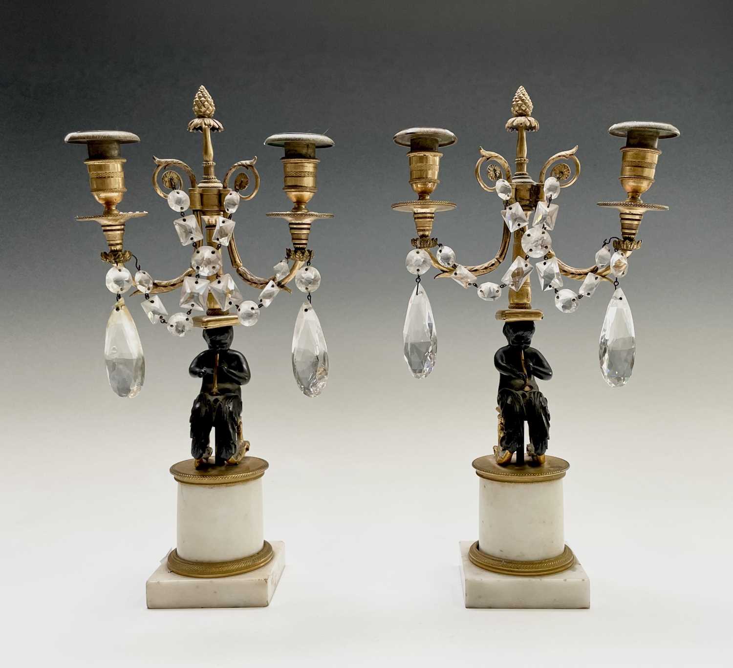 A pair of French bronze and gilt bronze candelabra, 19th century, each with a trumpeting satyr