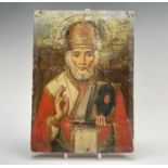 A Russian softwood icon, circa 1900, painted with St Nicholas, holding a bible, 23cm X 16.5cm