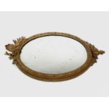 A Victorian oval gilt wall mirror, the gesso frame moulded with ribbons and flowerheads, height