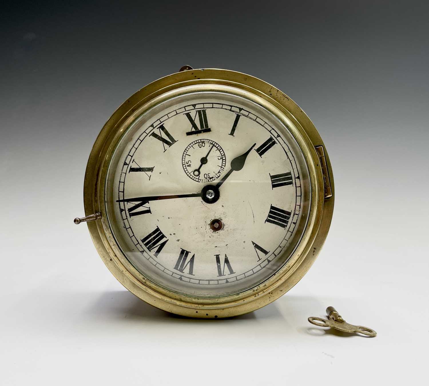 A brass cased ship's bulkhead wall clock, early 20th century, the painted dial with subsidiary