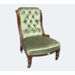 A late Victorian mahogany low salon chair, with green buttoned dralon upholstery and swept moulded