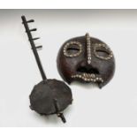 A 19th century African tribal mask, with applied snakeskin and cowrie shell decoration, height 27.