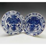 A pair of 18th century Dutch blue and white delft plates, the centres decorated with a floral