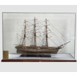 A wooden model of the Cutty Sark, with stained hull and gilt detail, on a stand and contained in a