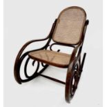 An early 20th century Thonet bentwood rocking chair with caned back and seat, bearing original