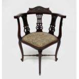 An Edwardian mahogany corner chair, with triple pierced and carved splats, on cabriole legs,
