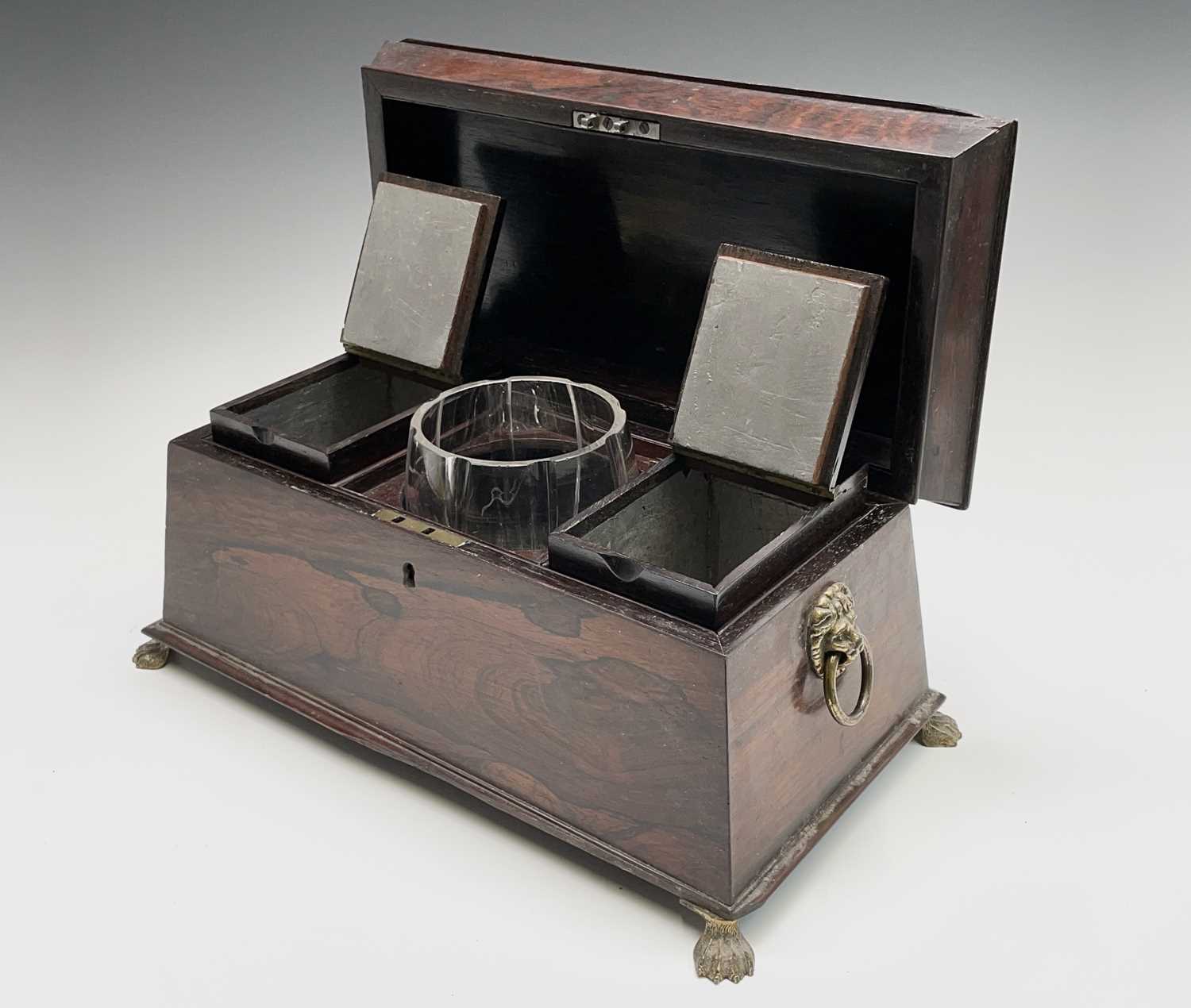A Regency rosewood tea caddy, of sarcophagus shape, with a glass mixing bowl and two lidded