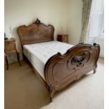 A French walnut bed, late 19th century, the foot and head with carved decoration, complete with side