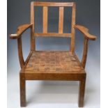 Robin Nance, An Arts and Crafts oak low open armchair, with slatted leather drop-in seat on square