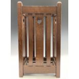 A Liberty & Co Arts & Crafts oak stick stand with heart cut-outs, and inset metal drip tray.