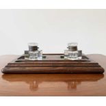 An oak deskstand, circa 1920's, fitted with two glass inkwells, width 26cm.