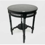 A late Victorian ebonised circular occasional table, with Gothic pierced frieze and raised on