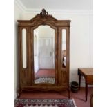 A French walnut wardrobe, late 19th century, the triple mirrored front with single door and raised
