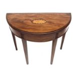 A George III mahogany demi lune fold over card table, the top with a shell inlaid oval panel and