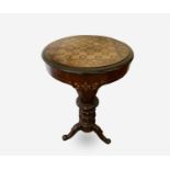 A Victorian walnut and inlaid sewing table, the circular top raised on a tapered and carved column