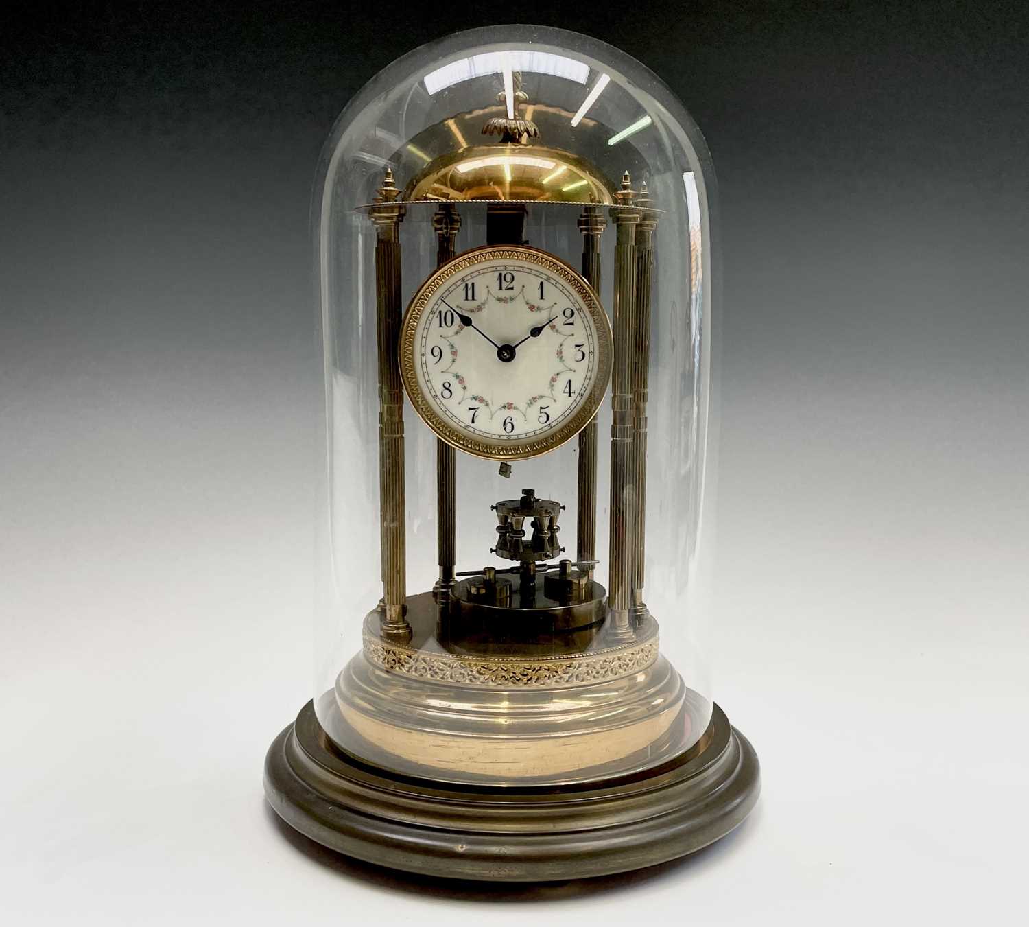 A 400 day brass torsion mantel clock, of portico type, with domed top, floral garland decorated dial