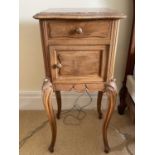 A French walnut bedside cupboard, late 19th century, with inset marble top above a drawer and