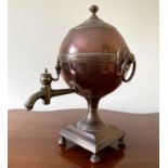 A Regency copper and brass tea urn, of spherical form on a square base, height 32cm.