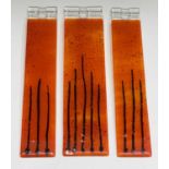 Three studio glass panels, with streaked orange colouring, height 6.5cm (3).
