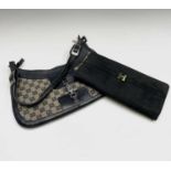 One black suede clutch bag and one other shoulder bag. The clutch with large interior compartment