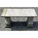 A garden bench, the marble slab seat raised on a pair of composition stone supports. Height 42cm,