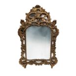 A George III giltwood mirror, the frame with Rococo scrolls and foliates, and wide mirrored