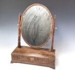 A George III coromandel oval swing toilet mirror, the base fitted with three drawers, height 59cm,