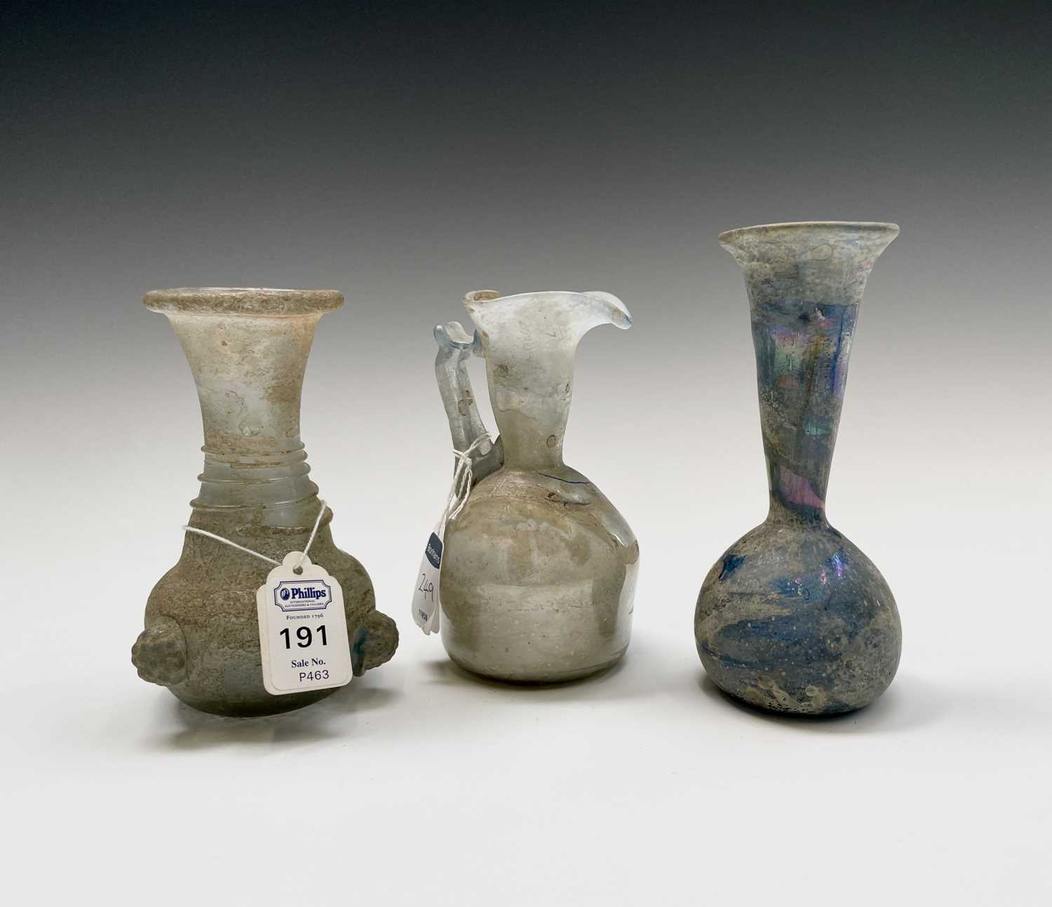 Three iridescent glass vessels, possibly Roman, comprising a ewer, height 13cm, and two vases. - Image 15 of 16