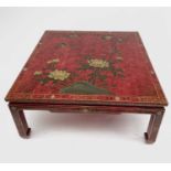 An oriental red lacquer low centre table, late 20th century, decorated in the Chinoiserie style.