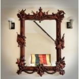 A mahogany ornate wall mirror, later 20th century, the frame carved with figures, dragons and