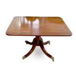 A George IV mahogany tilt top supper table, with rounded corners, on a tapering octagonal pillar and