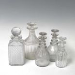 A pair of Regency triple ring neck glass decanters and stoppers, with faceted and fluted decoration,