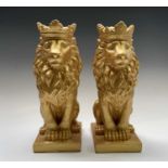 A pair of gold painted seated lions wearing crowns. Height 35cm.