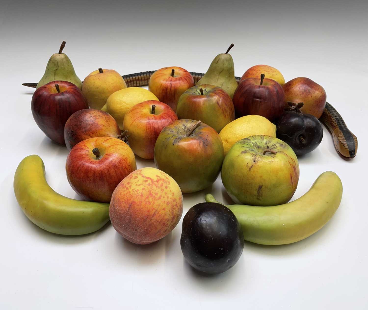 A collection of assorted wax fruit, including apples, bananas, lemons and pears, together with an
