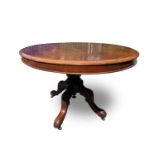 A Victorian mahogany tilt top oval table, raised on a turned column and leaf carved quadruped
