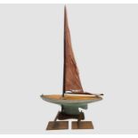 A painted wooden pond yacht, with simulated planked deck, white and green hull and leaded keel,