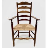 Robin Nance, An Arts and Crafts elbow ladder back elbow chair, with rush seat and turned supports,