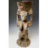 A large African carved wood statue of a female figure holding a bowl above her head. Height 89cm