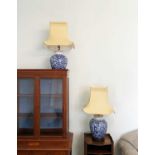 Pair of blue and white oriental table lamps, later 20th century, with gold shades and painted floral