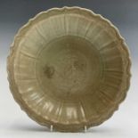 A Chinese Longquan celadon dish, Ming Dynasty, with a wide fluted border and scallop shaped rim,