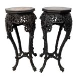 A pair of Chinese carved hardwood jardiniere stands, with an hexagonal marble inset top, above a