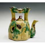 A Chinese sancai-glazed teapot, the spout and handle with opposing dragon masks, the fluted body