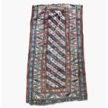 A Caucasian long rug, late 19th century, the indigo and ivory barbers pole field with hooked guls,