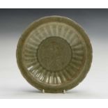 A Chinese Longquan celadon dish, Ming Dynasty, the centre with a floral spray within a fluted border