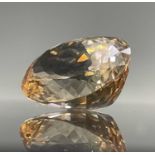 An oval imperial topaz of approximately 125cts, 35.6mmx26.6x18.3mm, unmounted