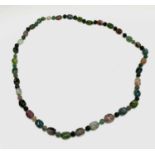 A Chinese necklace of 33 carved tourmaline beads the largest 15.09mm, these principle beads