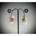 A pair of outlandish natural baroque pearl earrings with yellow mother of pearl flowers in enamelled