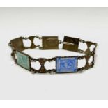 An Egyptian silver bracelet with six enamelled postage stamp links separated by enamel palmettes