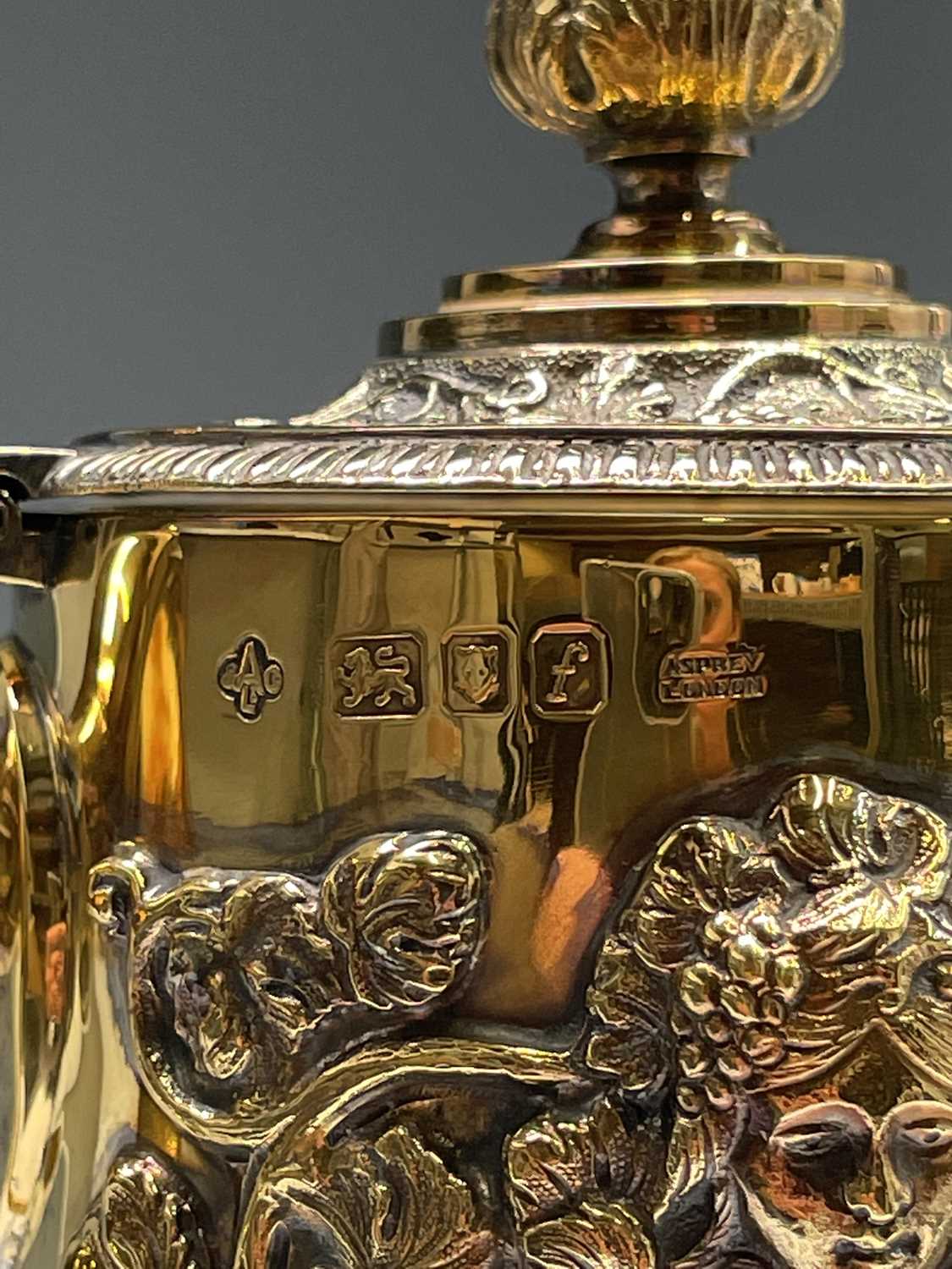 An Asprey claret jug the glass body cut and engraved with vines the silver-gilt mount with - Image 4 of 16