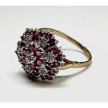 An impressive 9ct gold dress ring illusion set with diamonds amongst rubies Size R/S 3.7gm